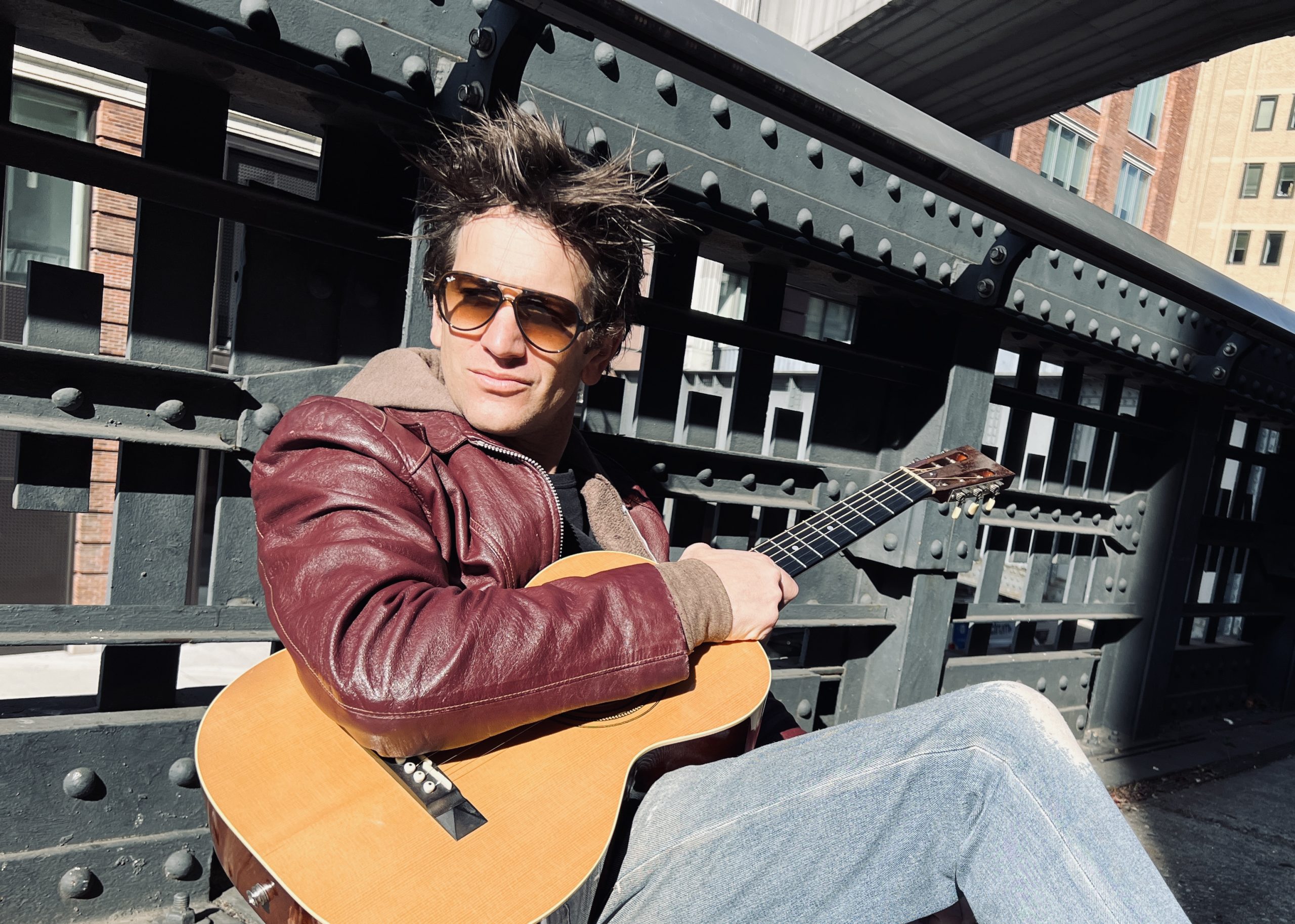 Gritty Indie Folk Singer Songwriter Dante Mazzetti with his guitar on The Highline in New York City